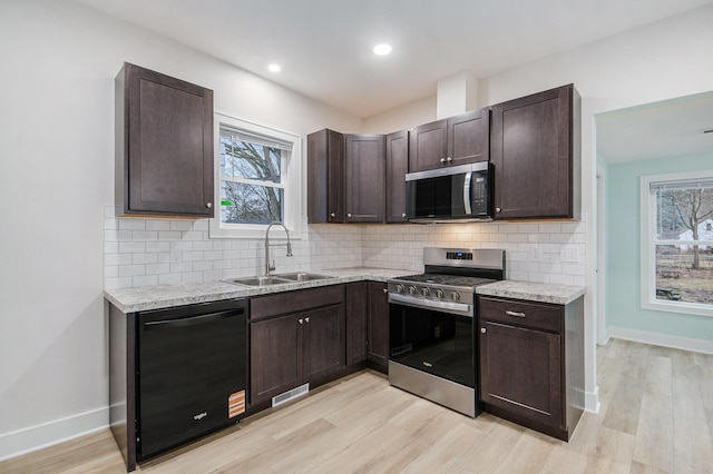 609 Lincoln Ave NW, Grand Rapids, MI 49504 - kitchen with appliances with stainless steel finishes, dark brown cabinets, plenty of natural light, and recessed lighting