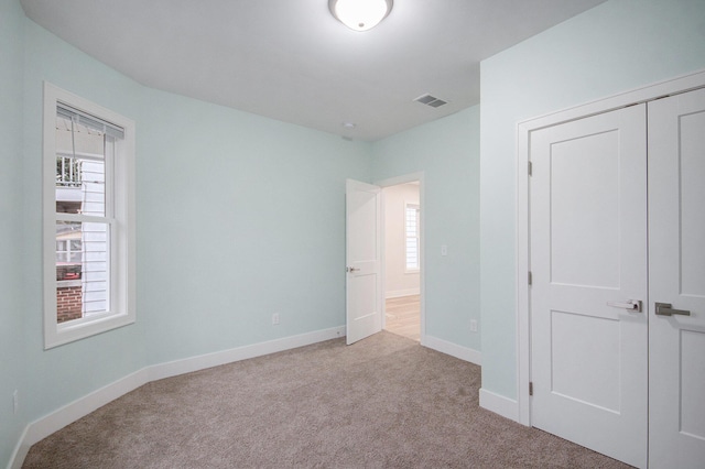 609 Lincoln Ave NW, Grand Rapids, MI 49504 - unfurnished bedroom featuring carpet floors, multiple windows, and a closet