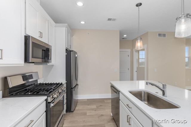 kitchen with a sink, visible vents, white cabinetry, and stainless steel appliances