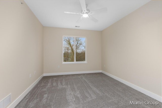 carpeted spare room with baseboards, visible vents, and ceiling fan