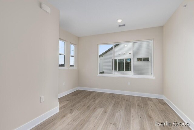 spare room featuring visible vents, baseboards, and light wood finished floors