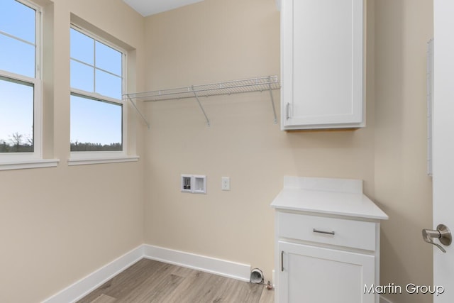laundry area with washer hookup, cabinet space, light wood-style floors, and baseboards