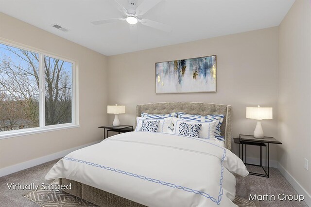 carpeted bedroom with visible vents, baseboards, and a ceiling fan