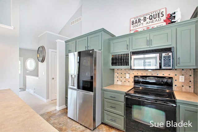 6735 Windflower Way, Norton Shores, MI 49444 - kitchen with appliances with stainless steel finishes, green cabinets, light countertops, and high vaulted ceiling