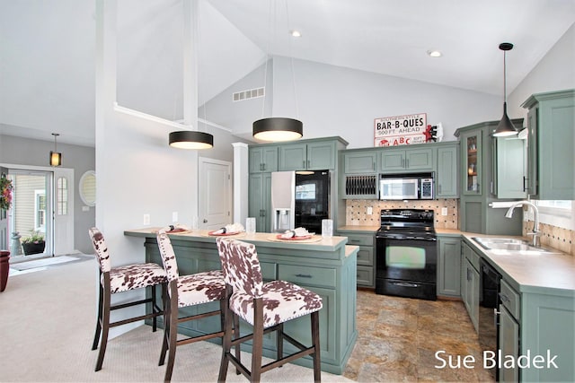 6735 Windflower Way, Norton Shores, MI 49444 - kitchen with black appliances, green cabinets, high vaulted ceiling, a breakfast bar area, and backsplash