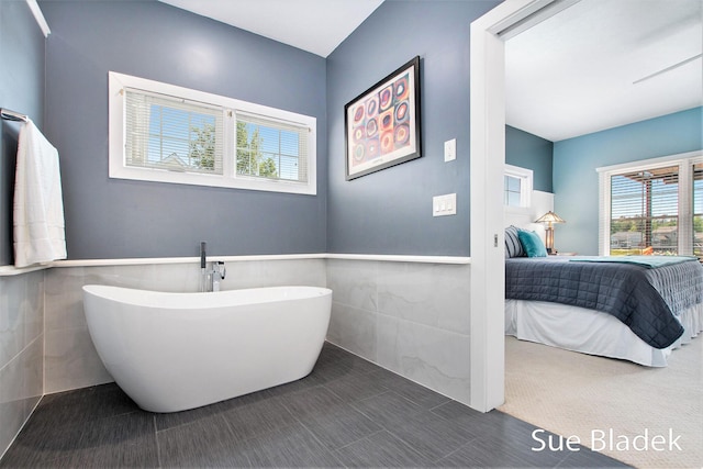 6735 Windflower Way, Norton Shores, MI 49444 - bathroom featuring connected bathroom, a soaking tub, tile walls, and wainscoting