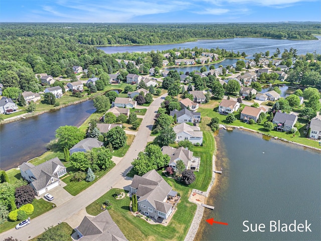 6735 Windflower Way, Norton Shores, MI 49444 - aerial view of residential area with a nearby body of water and a heavily wooded area