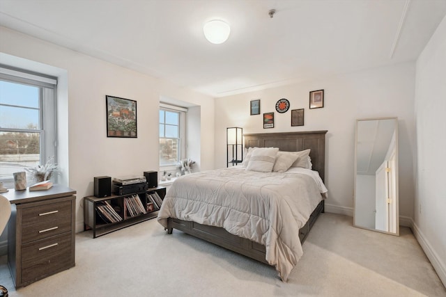 bedroom featuring baseboards and light colored carpet