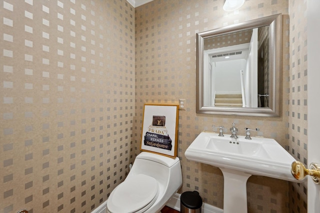 half bathroom featuring toilet and a sink