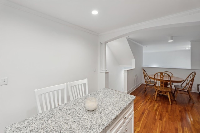 dining room with crown molding, baseboards, wood finished floors, recessed lighting, and arched walkways
