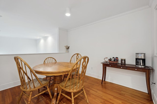 dining space with baseboards, wood finished floors, recessed lighting, and crown molding