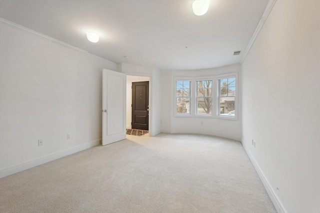unfurnished room featuring baseboards, ornamental molding, visible vents, and light carpet