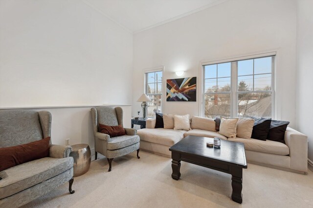living room featuring a high ceiling, light carpet, and ornamental molding