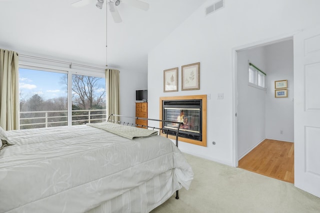 2019 Silvertip Ln, Long Beach, IN 46360 - carpeted bedroom featuring a glass covered fireplace, vaulted ceiling, multiple windows, and visible vents