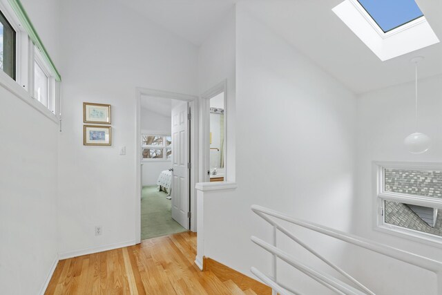 2019 Silvertip Ln, Long Beach, IN 46360 - hallway featuring a skylight, an upstairs landing, light wood-type flooring, and baseboards