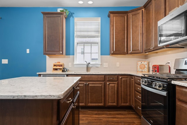 6337 S Trailwoods Dr, Ann Arbor, MI 48103 - kitchen with stainless steel appliances, a sink, backsplash, light stone countertops, and dark wood-type flooring