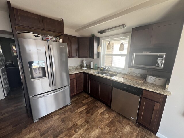 2772 S Wisner Ave, Fremont, MI 49412 - kitchen with light stone countertops, dark wood finished floors, dark brown cabinetry, stainless steel appliances, and a sink