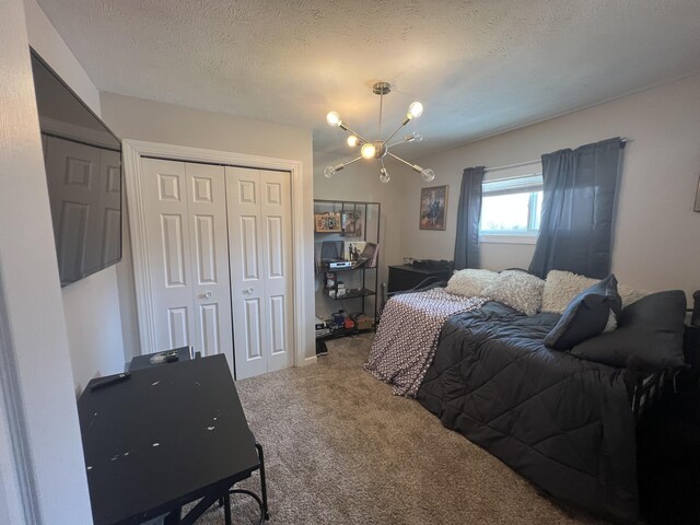 2772 S Wisner Ave, Fremont, MI 49412 - carpeted bedroom featuring a closet, a textured ceiling, and an inviting chandelier
