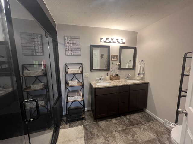 2772 S Wisner Ave, Fremont, MI 49412 - full bath with a sink, a textured ceiling, double vanity, and toilet