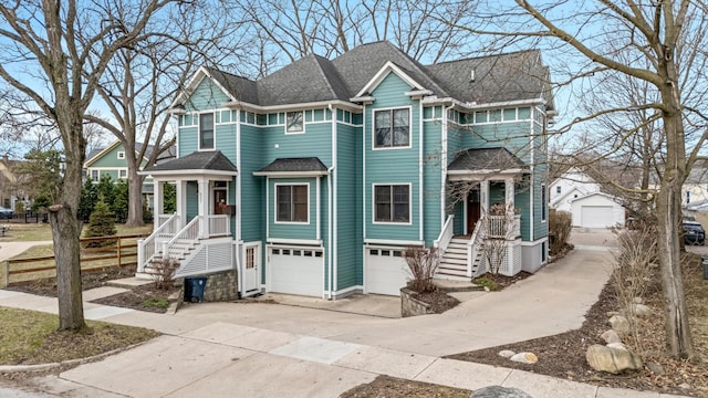 view of front of property featuring a garage, driveway, and roof with shingles