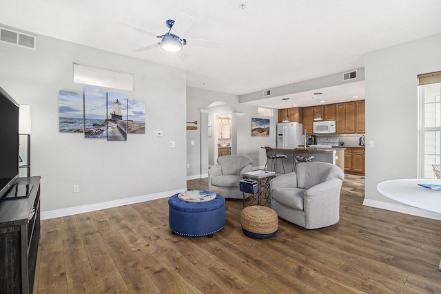 401 W Ludington Ave Unit 208, Ludington, MI 49431 - living room with visible vents, arched walkways, dark wood-type flooring, and ceiling fan