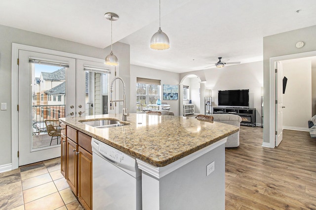 401 W Ludington Ave Unit 208, Ludington, MI 49431 - kitchen with a sink, brown cabinets, white dishwasher, a ceiling fan, and a kitchen island with sink