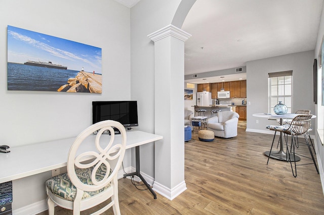 401 W Ludington Ave Unit 208, Ludington, MI 49431 - office area featuring baseboards, arched walkways, light wood-style flooring, and ornate columns