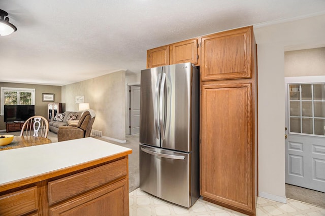 kitchen featuring freestanding refrigerator, light flooring, light countertops, and baseboards