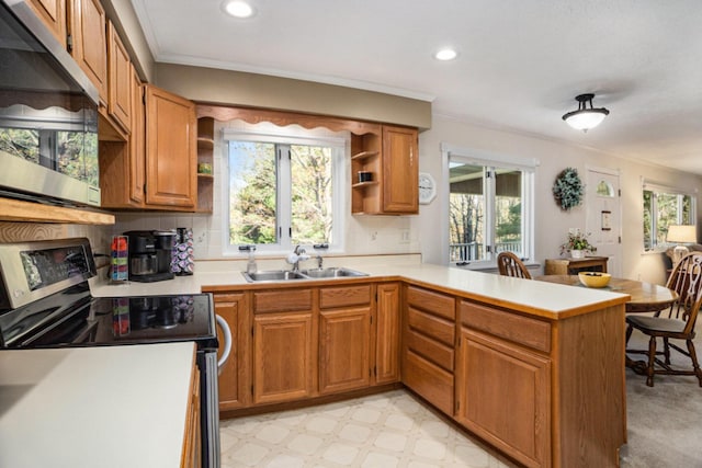 kitchen featuring appliances with stainless steel finishes, a sink, open shelves, a peninsula, and light countertops