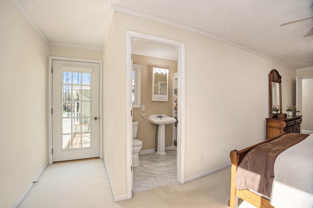 bedroom featuring crown molding, carpet floors, baseboards, ensuite bathroom, and a sink