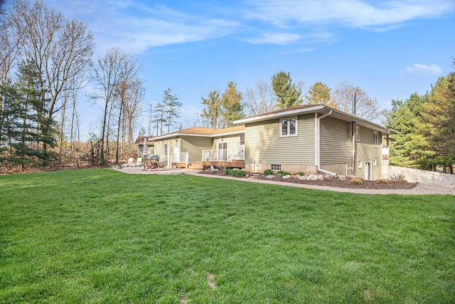 view of front facade with a front yard, a deck, and a patio
