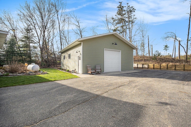 detached garage with asphalt driveway