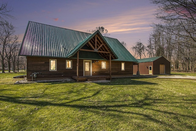 426 Elizabeth St, Buchanan, MI 49107 - view of front of house with metal roof, a detached garage, an outdoor structure, and a yard