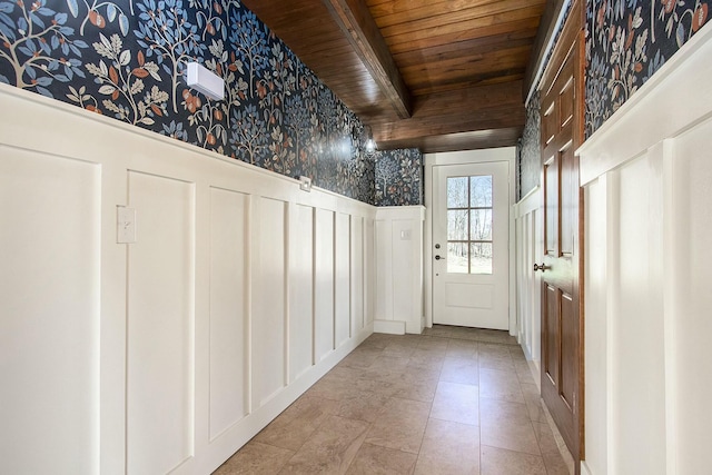 426 Elizabeth St, Buchanan, MI 49107 - doorway to outside featuring wooden ceiling, wallpapered walls, a wainscoted wall, beam ceiling, and a decorative wall