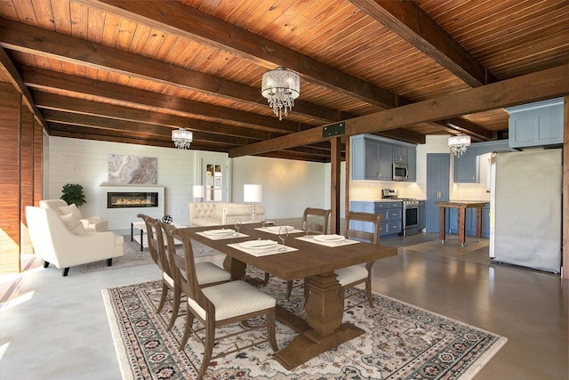 426 Elizabeth St, Buchanan, MI 49107 - dining area with finished concrete flooring, a notable chandelier, a glass covered fireplace, and beamed ceiling