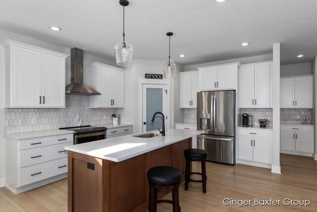 5560 Albright Ave SW Unit 67, Wyoming, MI 49418 - kitchen featuring white cabinetry, a sink, a kitchen island with sink, appliances with stainless steel finishes, and wall chimney exhaust hood