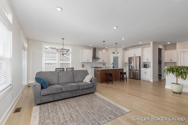 5560 Albright Ave SW Unit 67, Wyoming, MI 49418 - living area with light wood-style flooring, visible vents, baseboards, recessed lighting, and an inviting chandelier