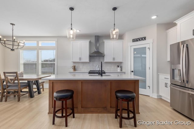 5560 Albright Ave SW Unit 67, Wyoming, MI 49418 - kitchen featuring light countertops, stainless steel fridge, decorative backsplash, light wood-style floors, and wall chimney range hood