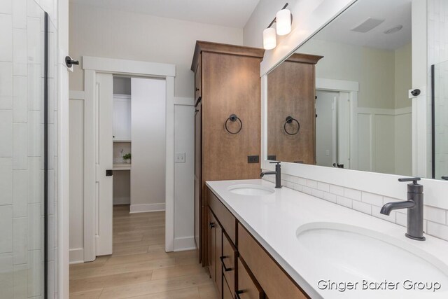 5560 Albright Ave SW Unit 67, Wyoming, MI 49418 - bathroom featuring double vanity, a sink, wainscoting, and wood finished floors