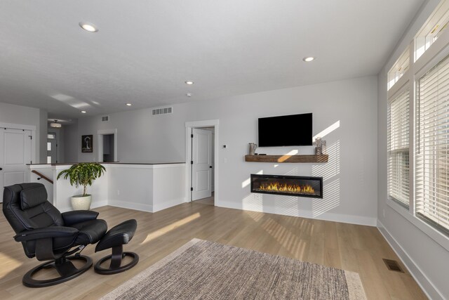 5560 Albright Ave SW Unit 67, Wyoming, MI 49418 - sitting room featuring light wood-style flooring, visible vents, baseboards, recessed lighting, and a glass covered fireplace