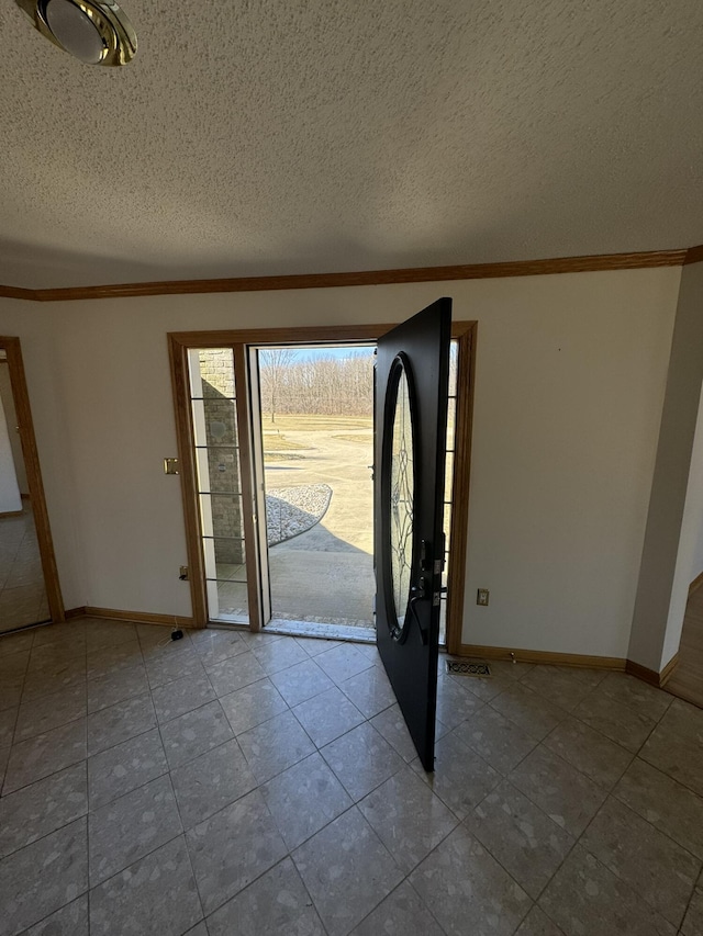 foyer entrance featuring baseboards, crown molding, and tile patterned flooring