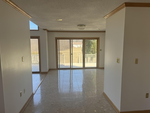 unfurnished room with baseboards, ornamental molding, and a textured ceiling