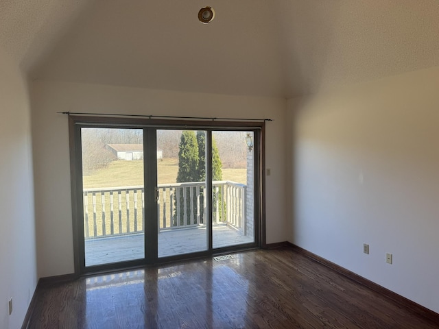 unfurnished room with baseboards, wood finished floors, and visible vents