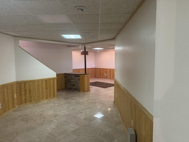 finished below grade area with wood walls, wainscoting, and a paneled ceiling