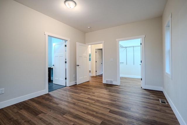 3935 W Destiny Dr, Hart, MI 49420 - unfurnished bedroom with dark wood-style floors, visible vents, and baseboards