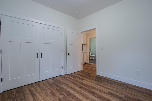3935 W Destiny Dr, Hart, MI 49420 - unfurnished bedroom with a closet, baseboards, and dark wood finished floors