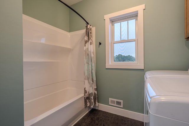 3935 W Destiny Dr, Hart, MI 49420 - bathroom featuring washer and dryer, visible vents, baseboards, and shower / tub combo with curtain