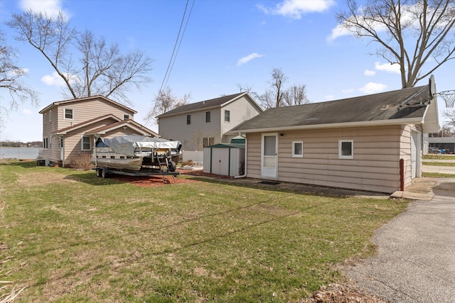 1169 Shady Shores Dr, Niles, MI 49120 - rear view of property featuring an outbuilding, central AC unit, driveway, a storage shed, and a lawn
