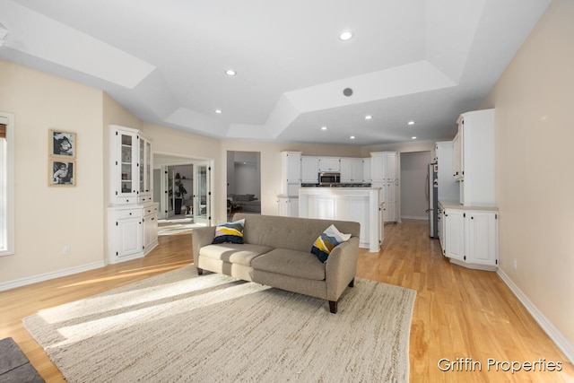 7834 Strawberry Ln NE, Belmont, MI 49306 - living room featuring a tray ceiling, light wood-style flooring, recessed lighting, and baseboards