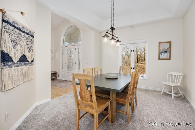 7834 Strawberry Ln NE, Belmont, MI 49306 - dining area with a tray ceiling, baseboards, and light colored carpet